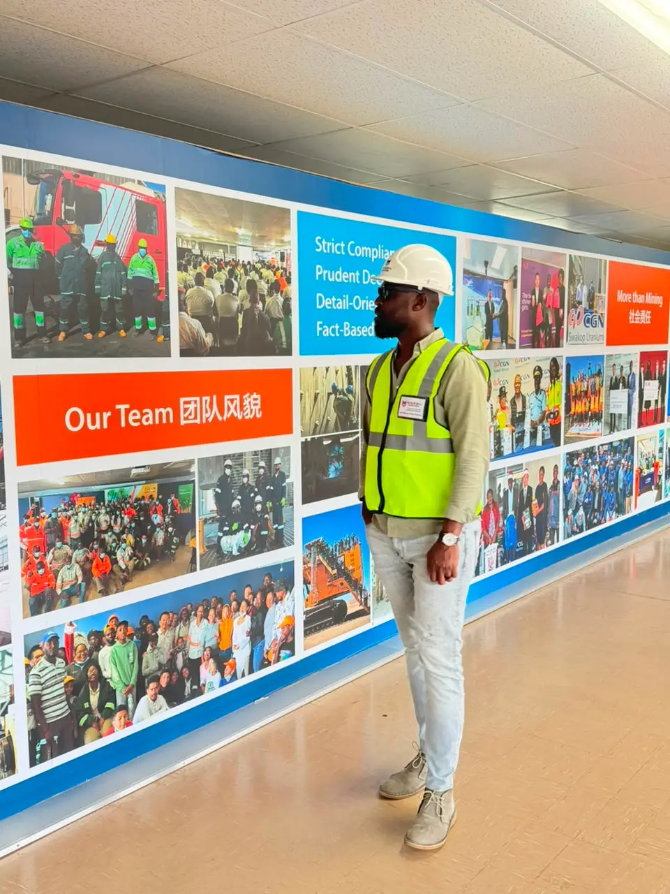 Man in a hi-vis vest and hard hat in a mine facility corridor