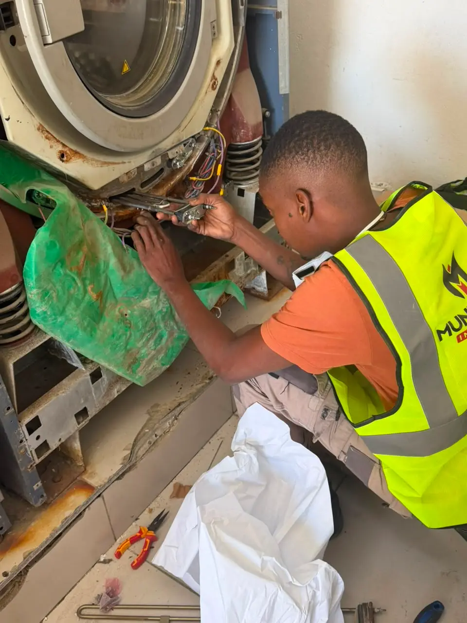 Technician repairing the wiring of an industrial washing machine